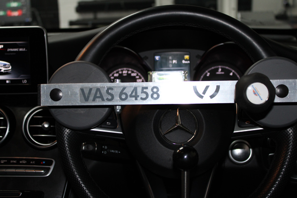 Mercedes-Benz steering wheel with a metallic gauge and the code VAS 6458, showcasing a detailed dashboard view.